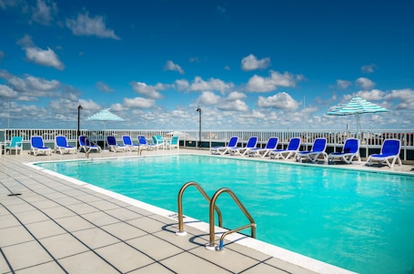 Una piscina techada, una piscina al aire libre de temporada, sombrillas