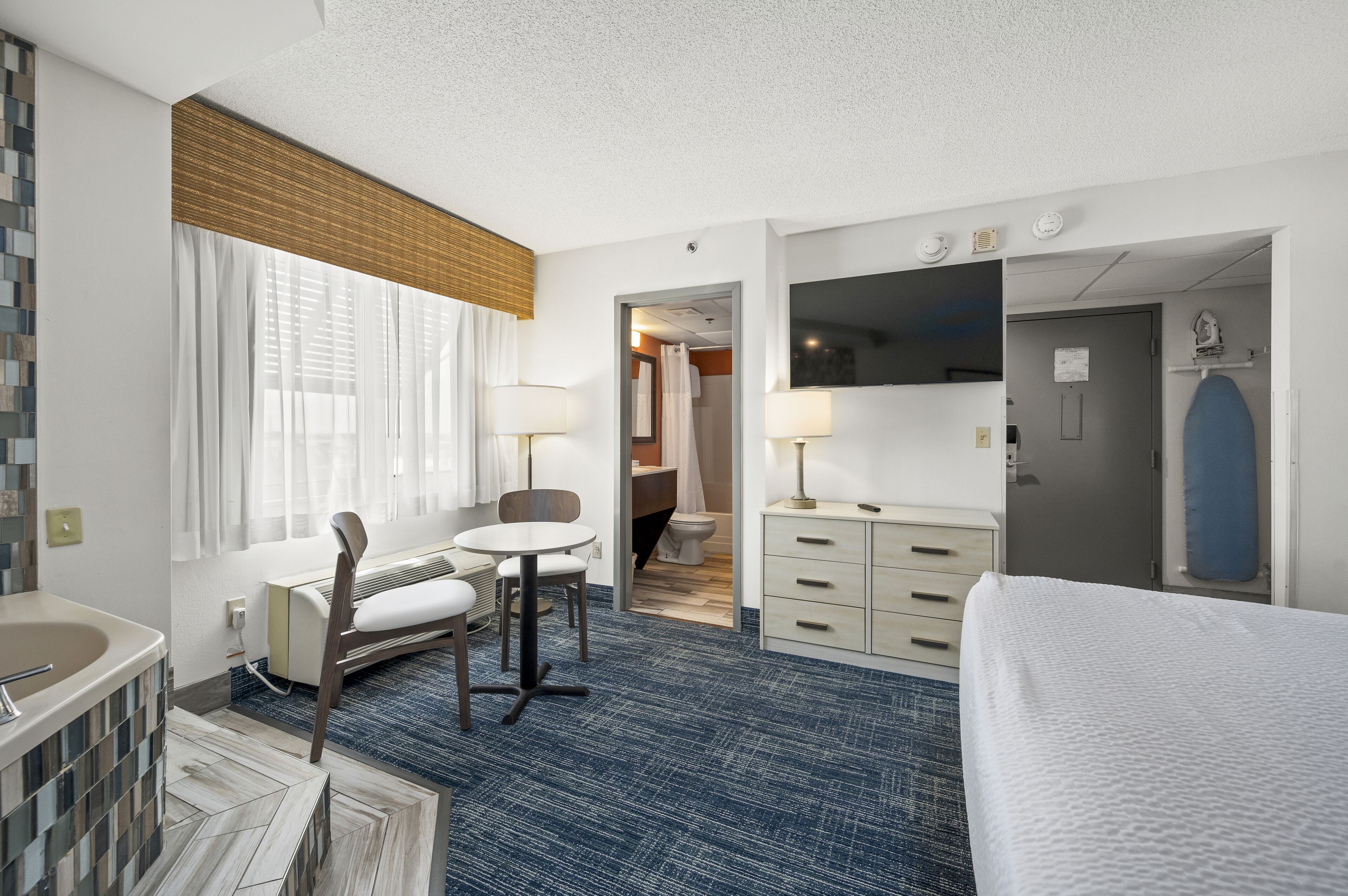 غرفة فردية - سرير ملكي - بحوض استحمام بنظام دفع المياه | خزنة داخل الغرفة ومكتب وستائر تعتيم ومكواة/لوح كي