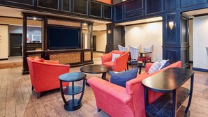 A spacious lobby with a large flat-screen TV, comfortable seating, and a wooden floor. - Hampton Inn & Suites Waco-South (Waco)