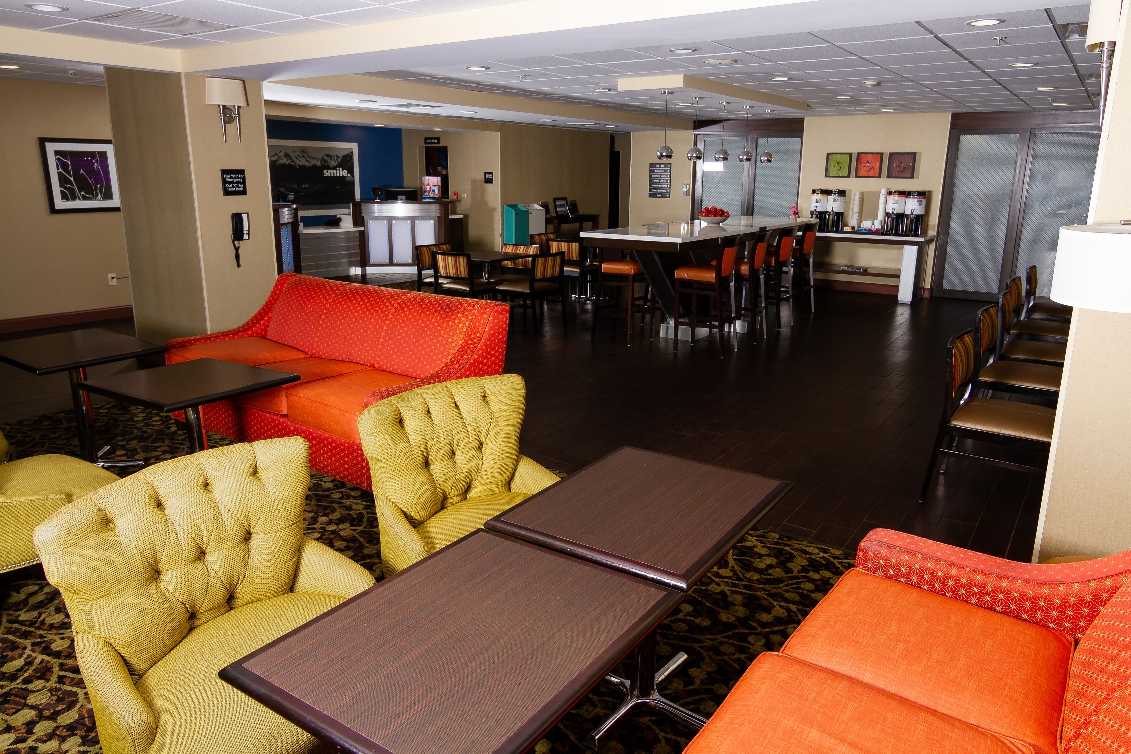 A hotel lobby with seating areas, a bar, and a reception desk.