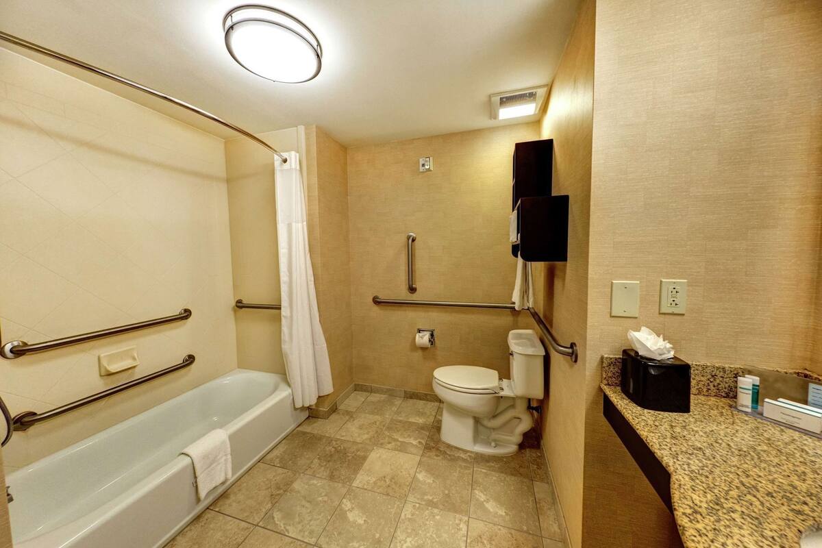 A bathroom with a bathtub, toilet, and shower.