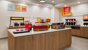 A breakfast bar with a coffee machine, a fruit basket, and a juice dispenser. - Hampton Inn & Suites Chadds Ford (Glen Mills)