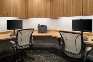 A modern office space with two desks, two chairs, a printer, and a TV. - Hampton Inn & Suites Chadds Ford (Glen Mills)