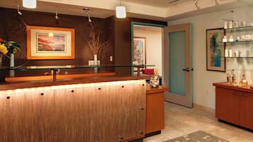 A reception area with a wooden counter, glass display shelves, and framed artwork.