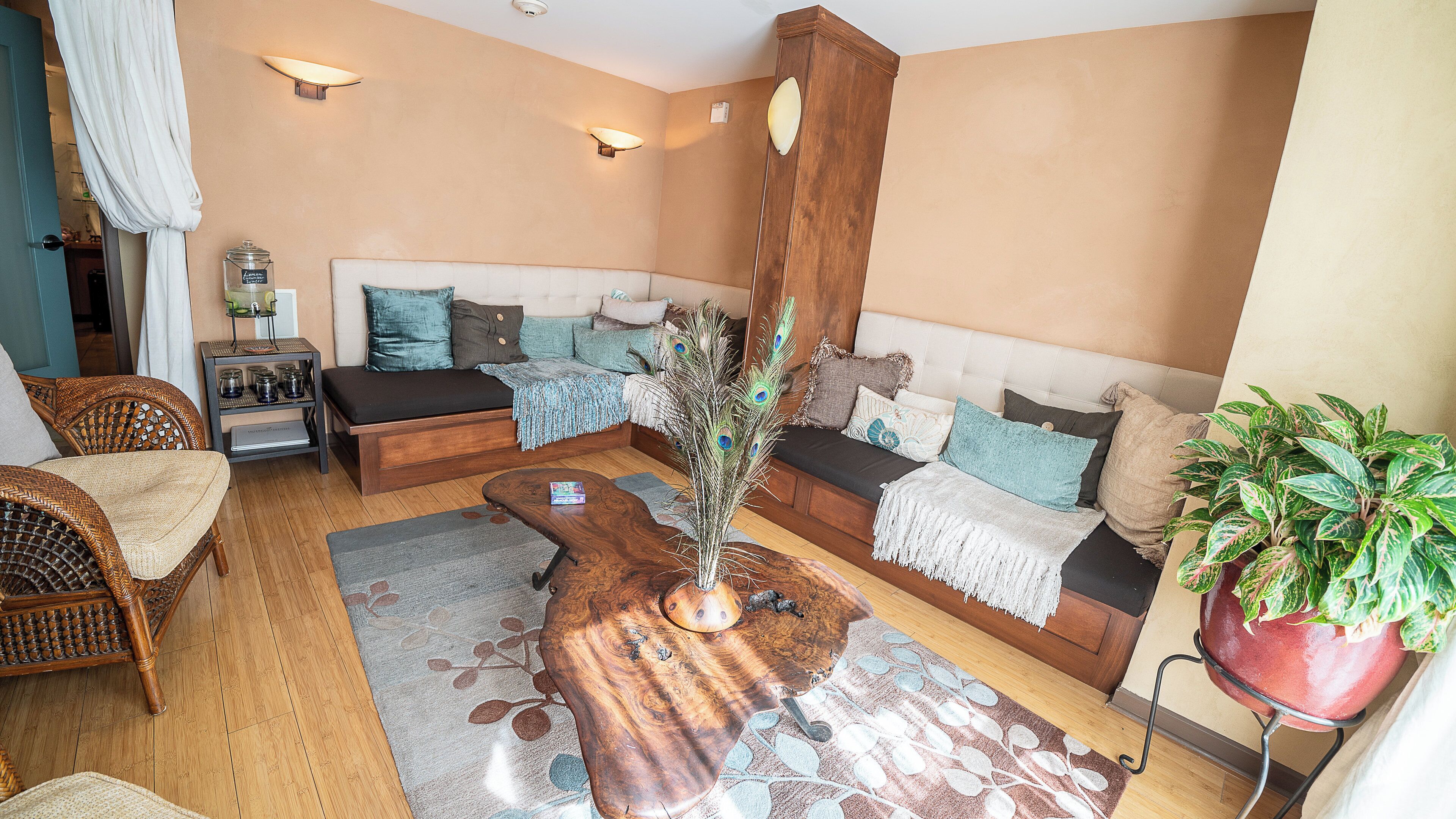 Una sala acogedora con un sofá, sillones, una mesa de centro y una planta en maceta.