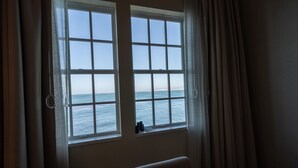 A room with a large window overlooking the sea, a towel on the floor, and a small table with items on it. - InterContinental the Clement Monterey by IHG (Monterey)