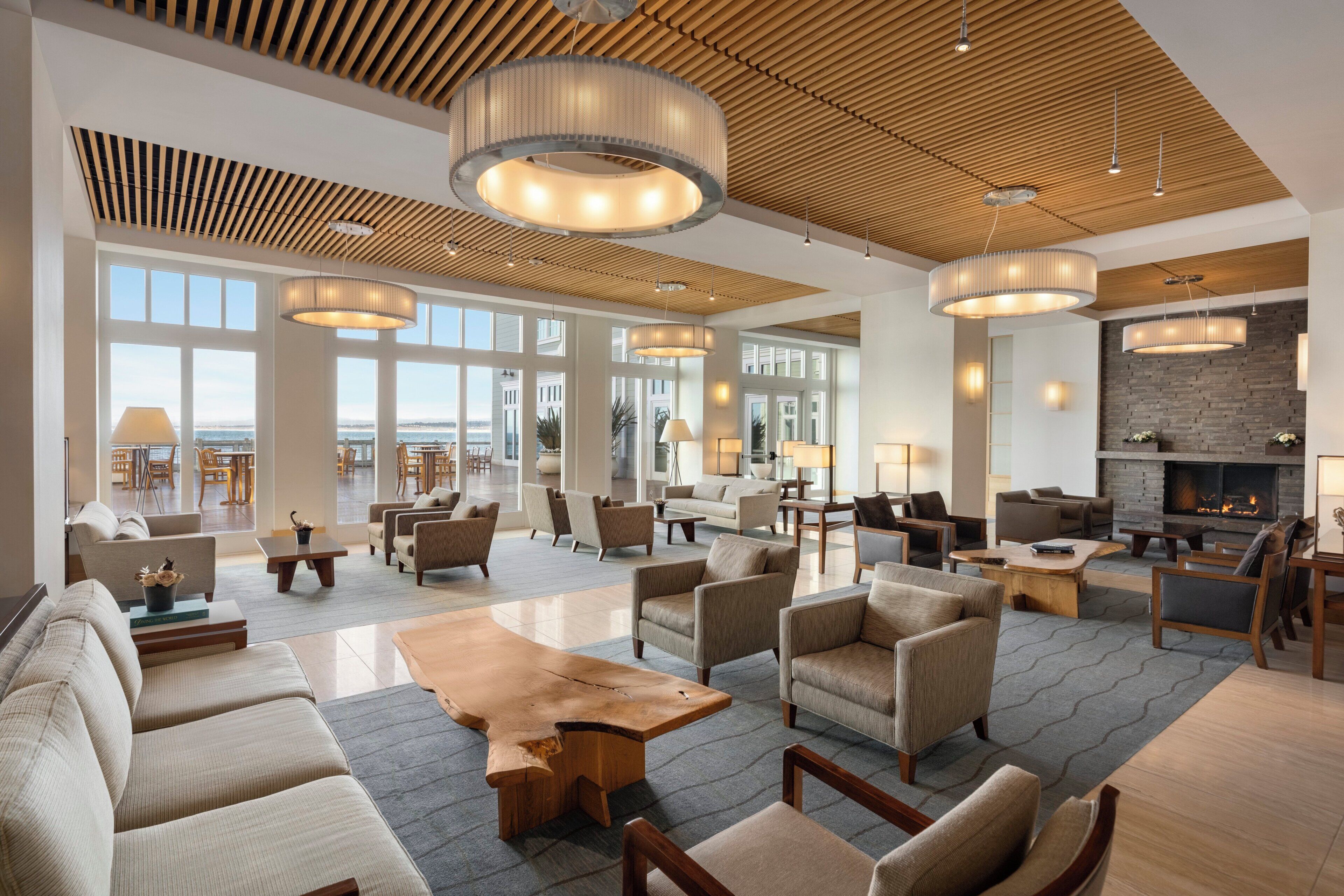 A spacious lobby with a fireplace, multiple seating areas, and large windows offering views.