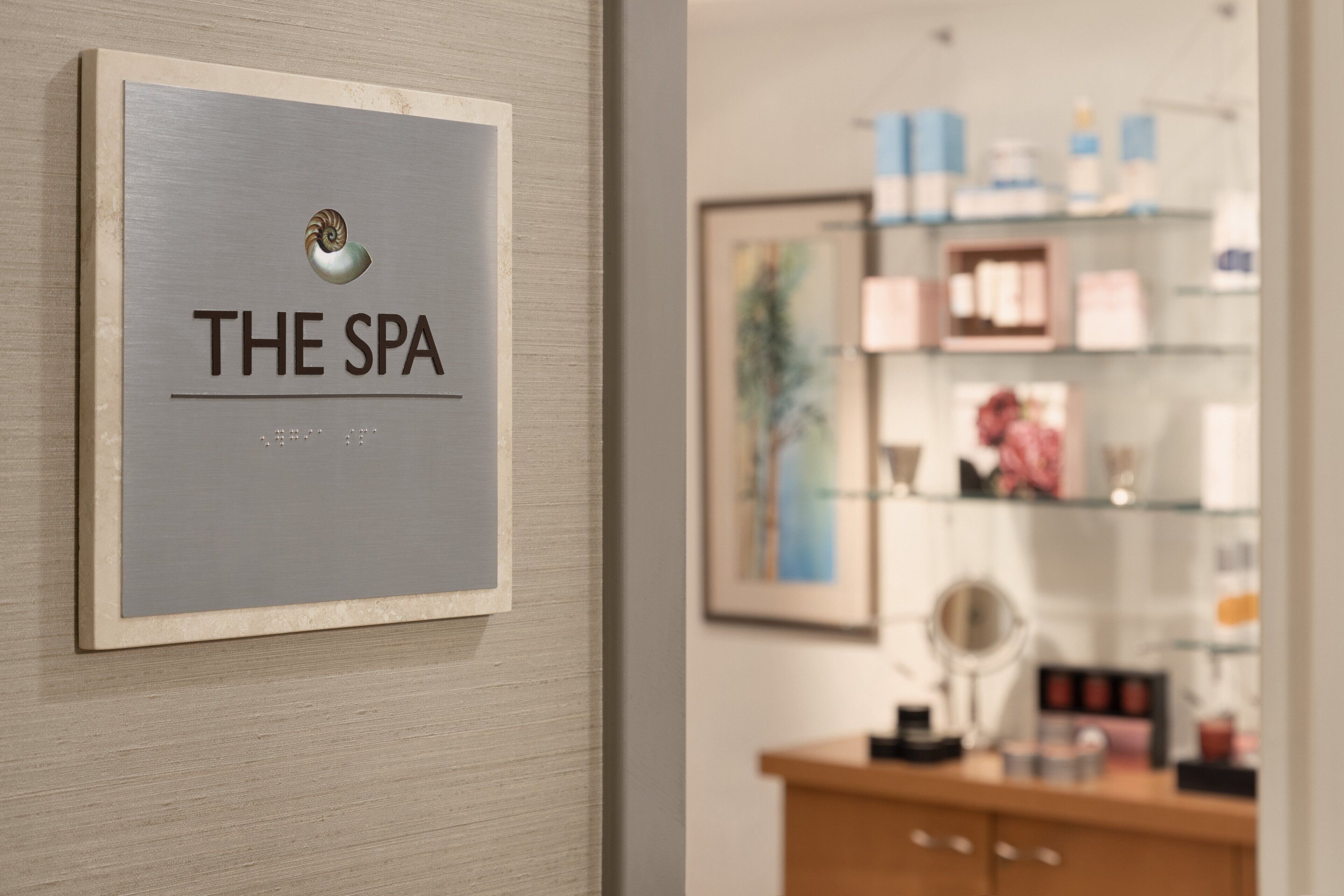 Ein Spa-Schild mit einem Muschelsymbol und dem Schriftzug „THE SPA“.