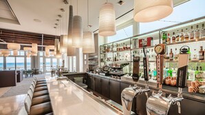 A bar area with seating, a bar counter, and a view of the sea. - InterContinental the Clement Monterey by IHG (Monterey)