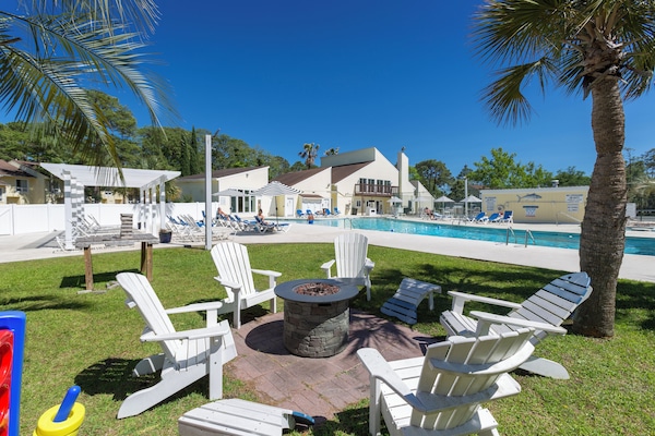 Una piscina techada, una piscina al aire libre, sombrillas