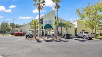 A building with a sign for 'The Links Golf & Country Club' and a parking lot with several vehicles.