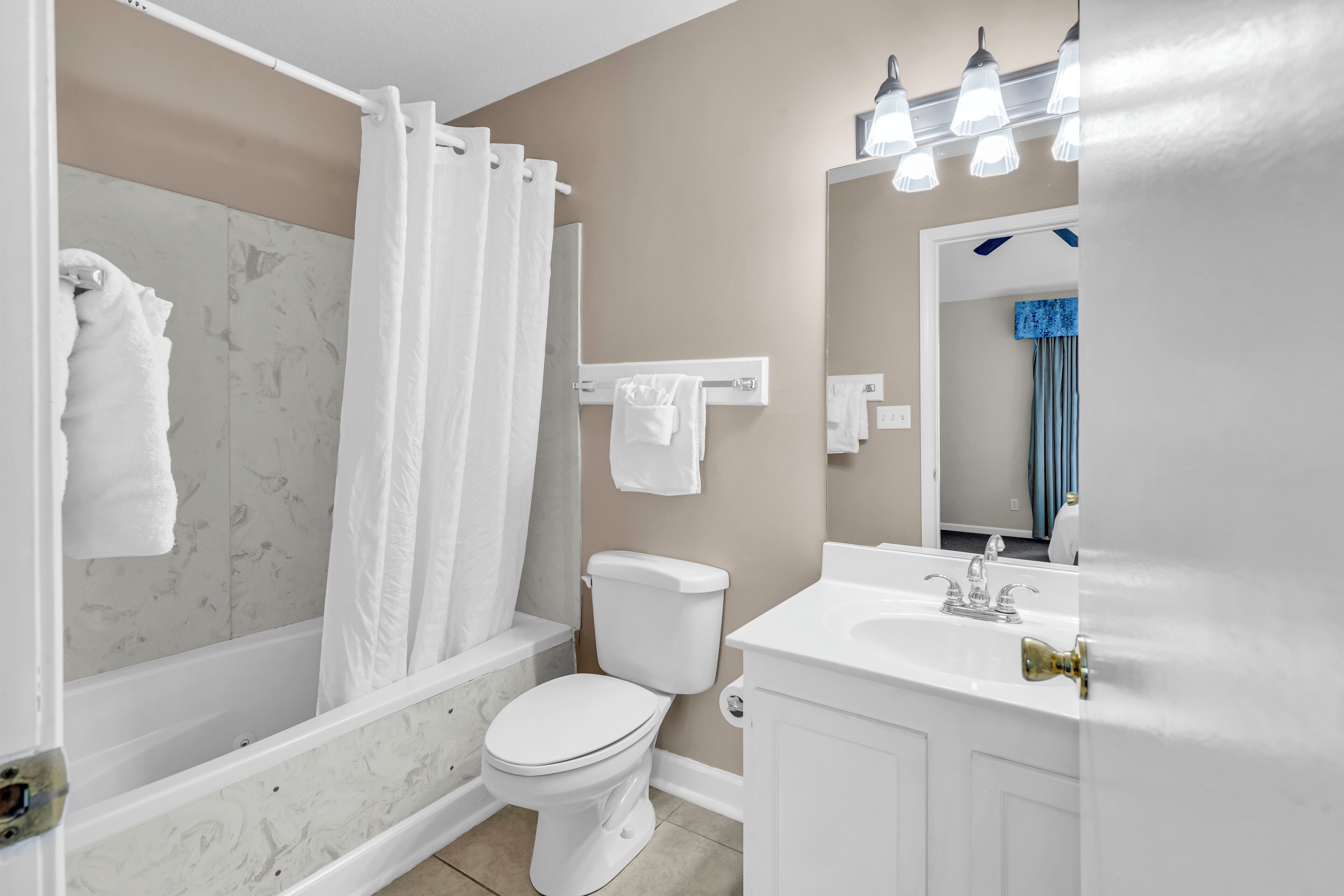 A bathroom with a bathtub, toilet, and sink.