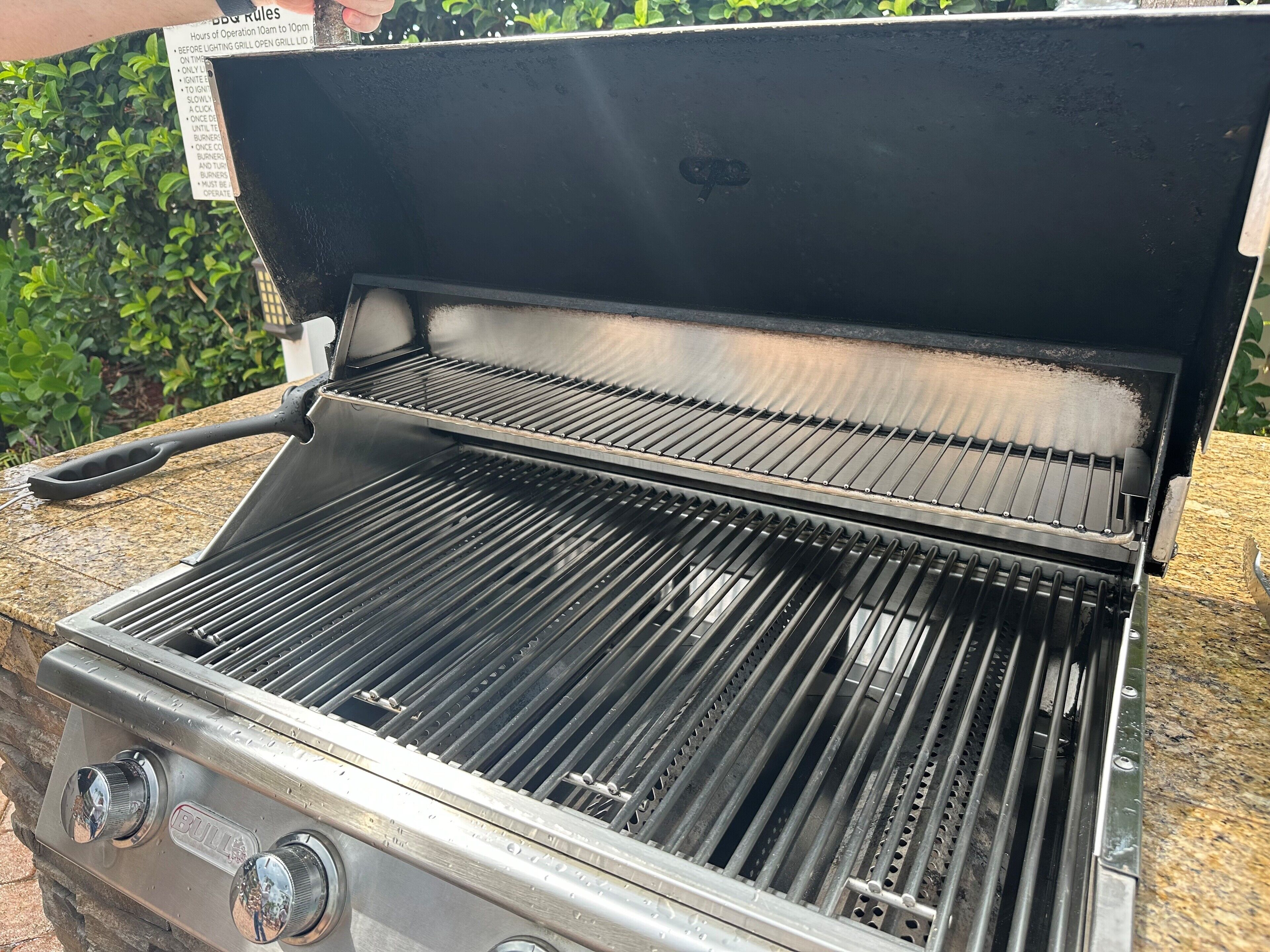 Un barbecue en acier inoxydable doté d’un couvercle, d’un panneau de commande avec des boutons et d’une grille en métal.
