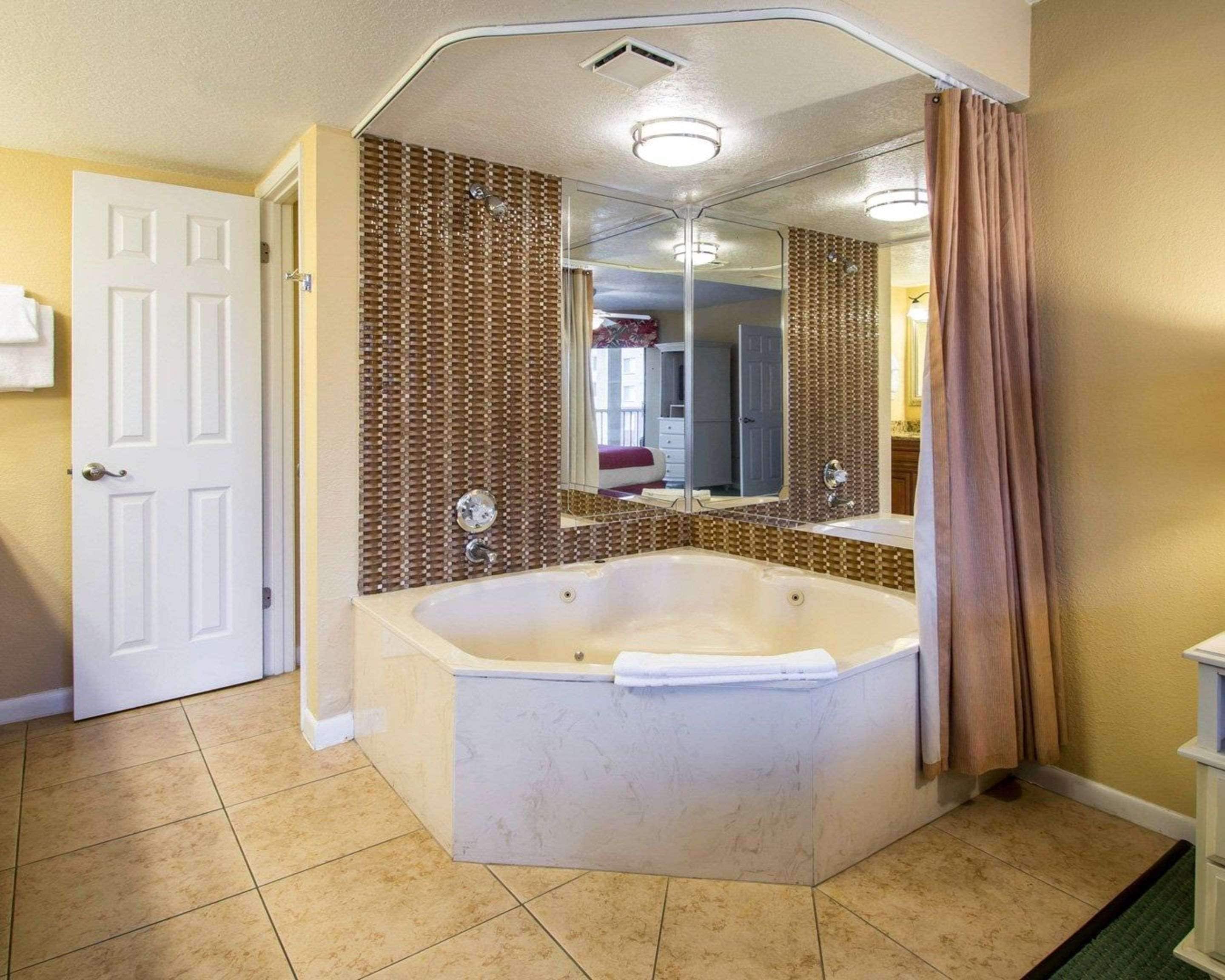 Een badkamer met een groot bad, een douche en een spiegel.