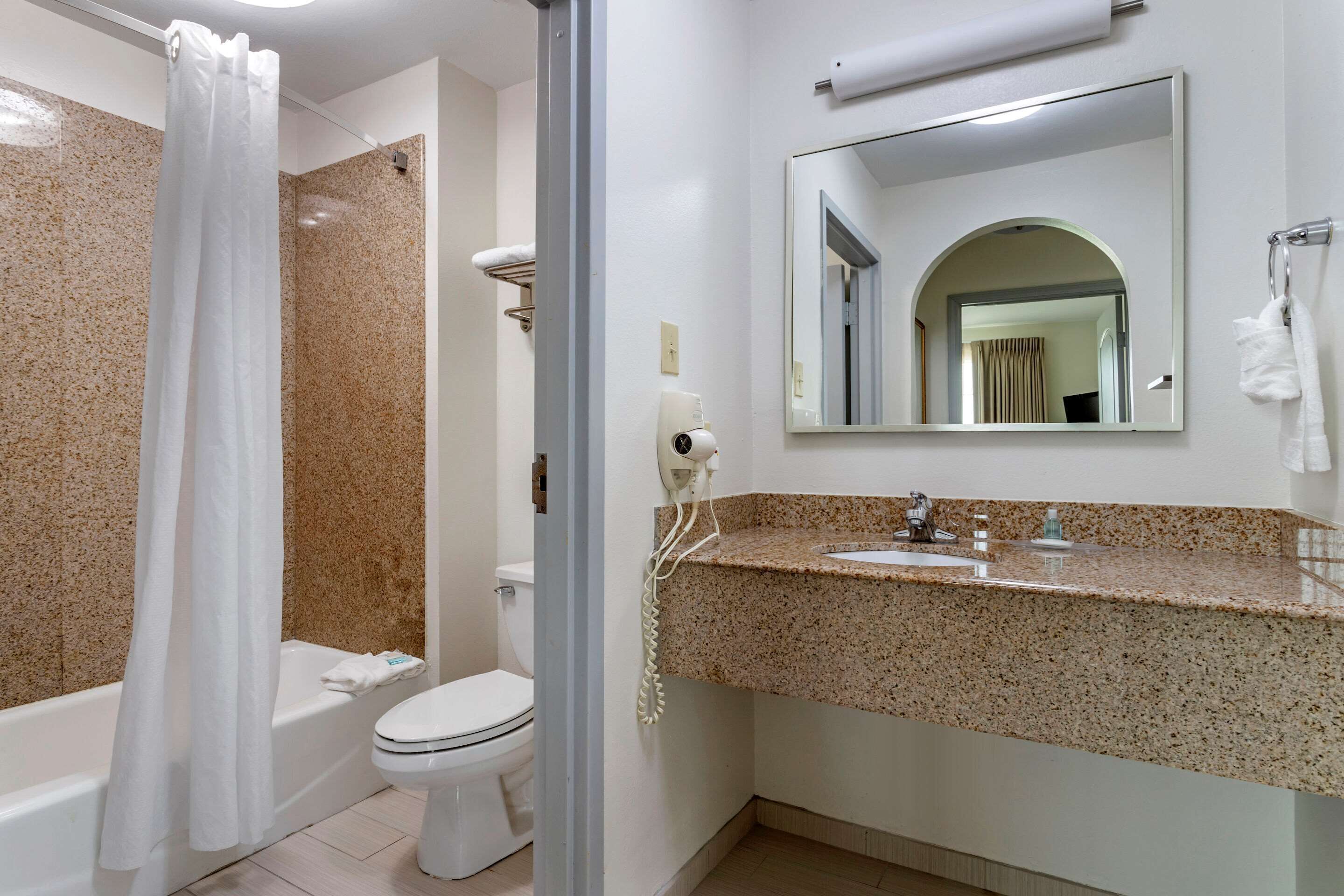 A bathroom with a shower, toilet, and sink.