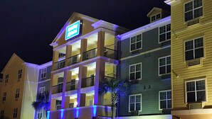 Ein mehrstöckiges Hotel mit auffälliger Beschilderung, Balkonen und einer gut beleuchteten Fassade.