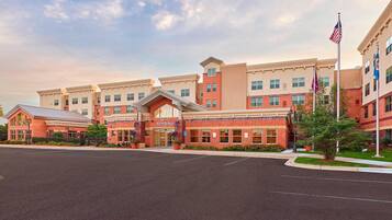 Hotel entrance with covered walkway and flags.