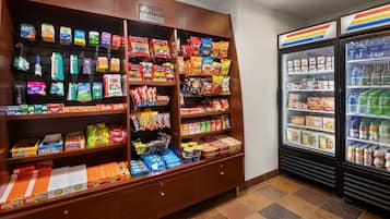 A snack display with various packaged goods and a refrigerated section with beverages.