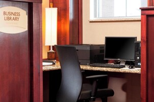 A business library desk with a computer, a lamp, and a chair.