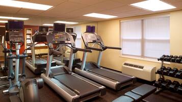 A gym with treadmills, weights, and benches.