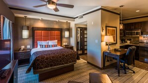 A hotel room with a large bed, a desk, a chair, a ceiling fan, a microwave, and a refrigerator. - Staybridge Suites DFW Airport North by IHG (Irving)