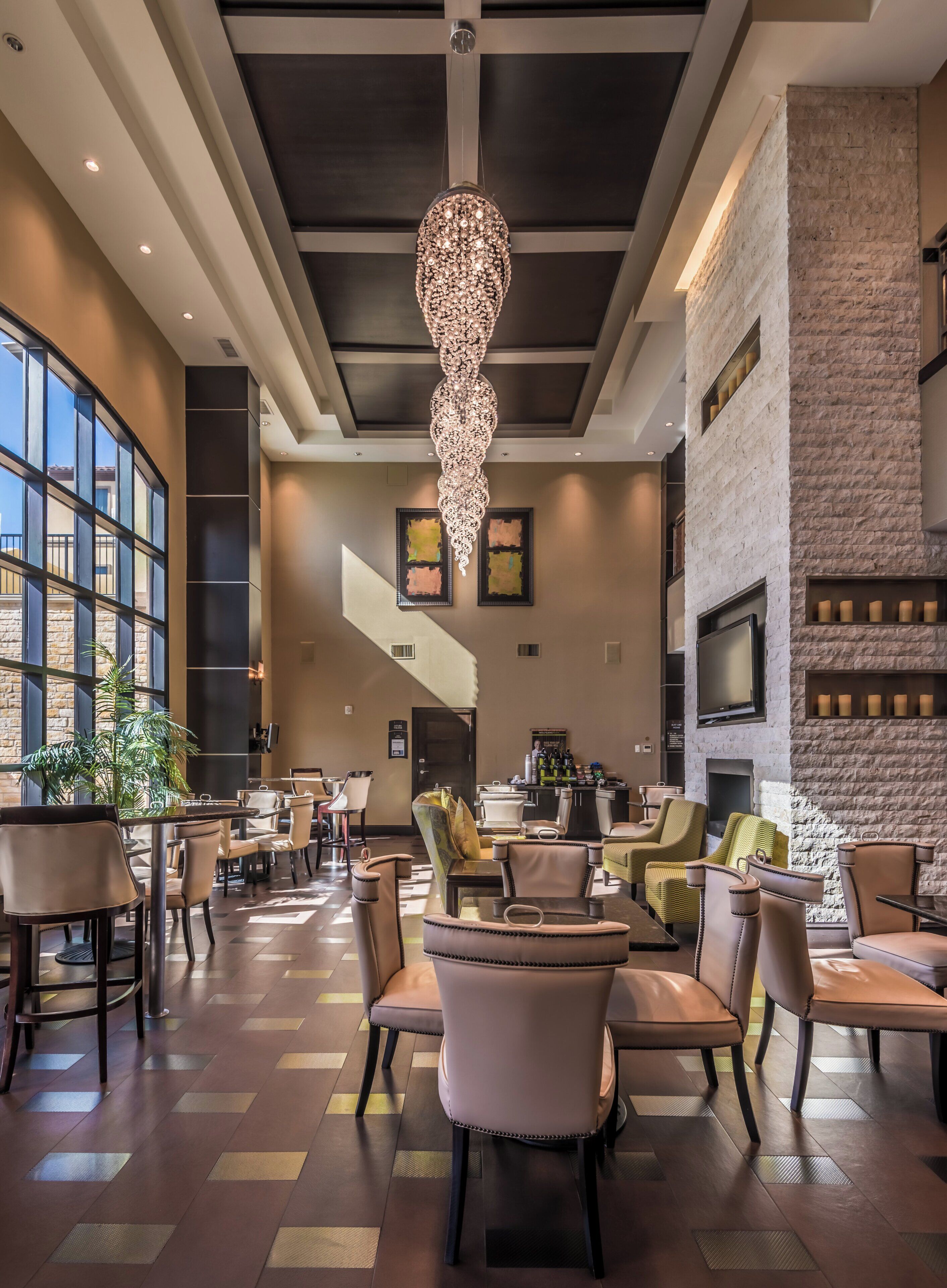 A spacious lobby with a chandelier, seating area, and a fireplace.