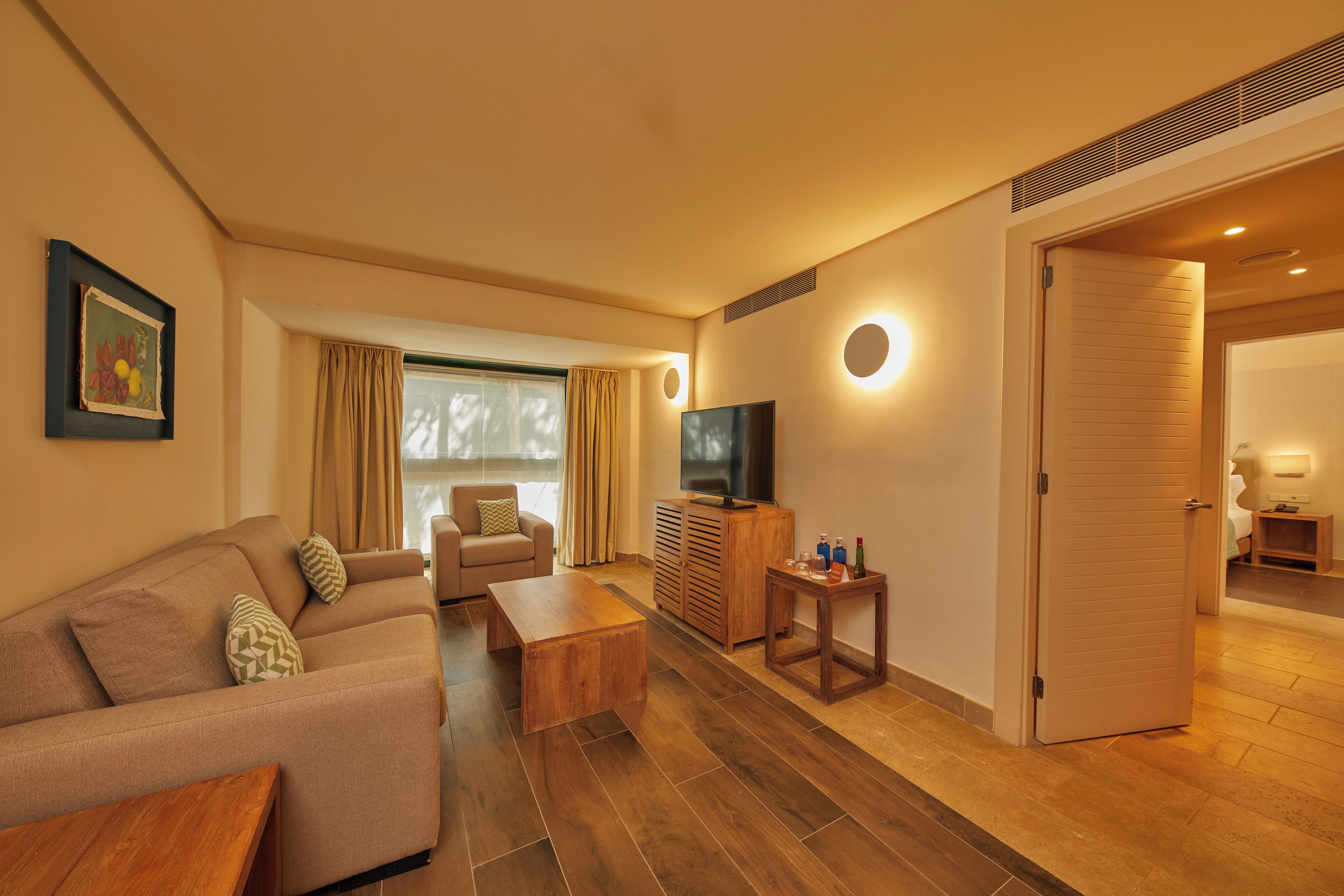 Een moderne woonkamer met een bank, salontafel, televisie en een houten kast.