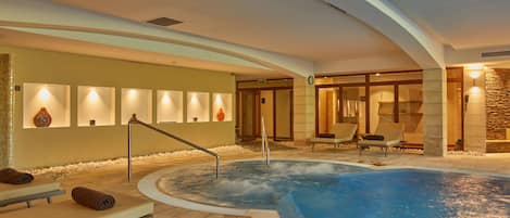 A spa area with a hot tub, seating, and a wall with lights.