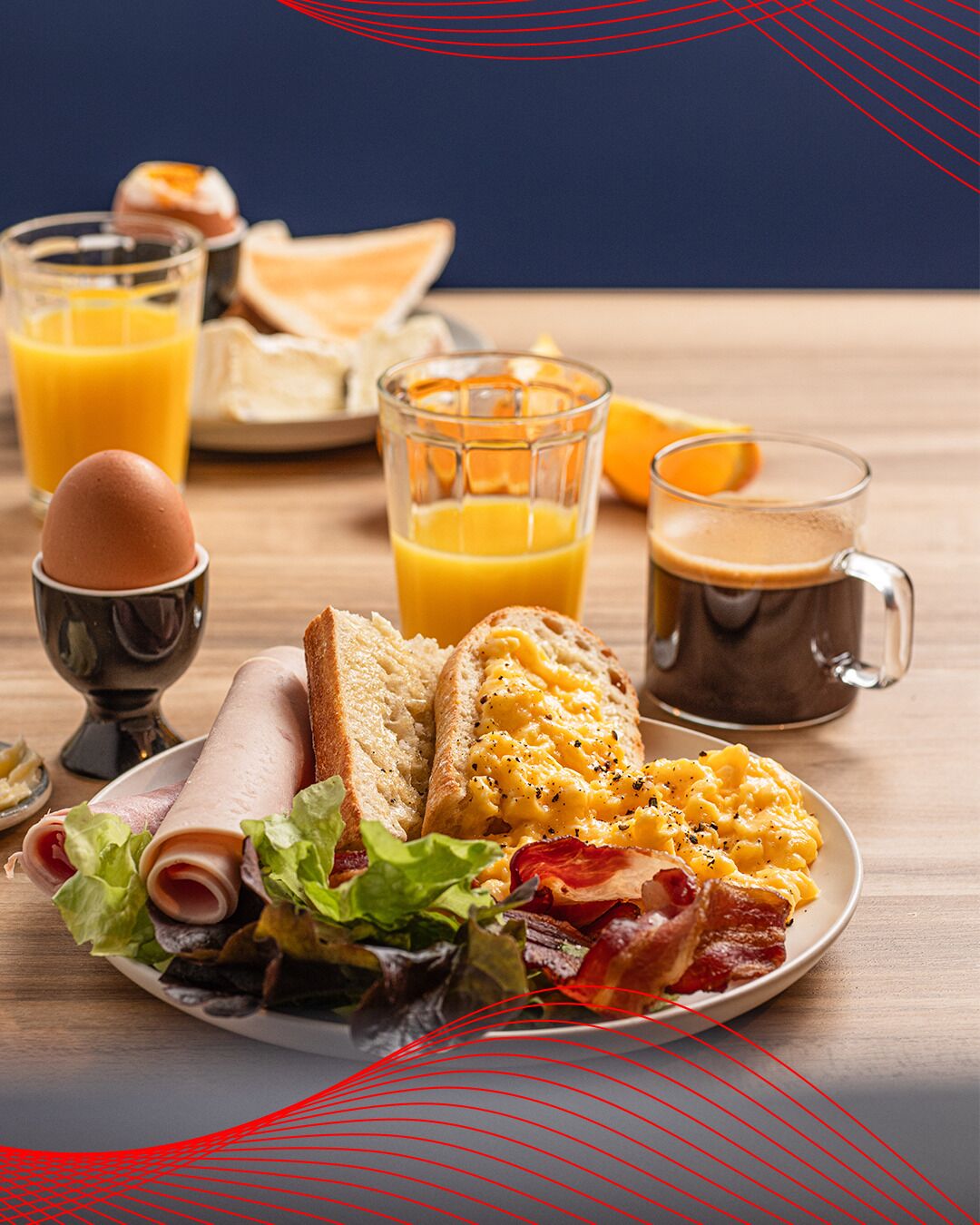 A breakfast plate with eggs, bacon, ham, and toast, accompanied by orange juice and coffee.