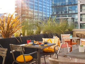 An outdoor seating area with a table, chairs, and potted plants. - Ibis Marseille Centre Euromed (Marseille)