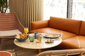 Enjoy a delicious breakfast in this inviting sitting area with a round table set and comfortable seating.