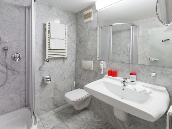 A modern bathroom with a shower, toilet, and sink.
