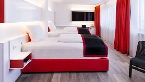 A modern hotel room with a large bed, a desk, and a TV.