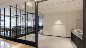 A modern interior with glass partitions, a reception area, and a visible dining space. - Sapporo Grand Hotel (Sapporo)