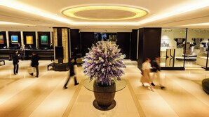 A modern lobby with a central floral arrangement, a reception desk, and a seating area. - Sapporo Grand Hotel (Sapporo)