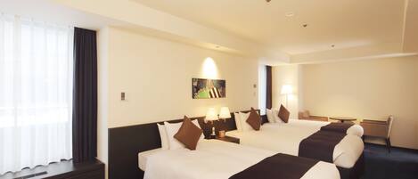 A hotel room with two beds, a desk, and a chair.