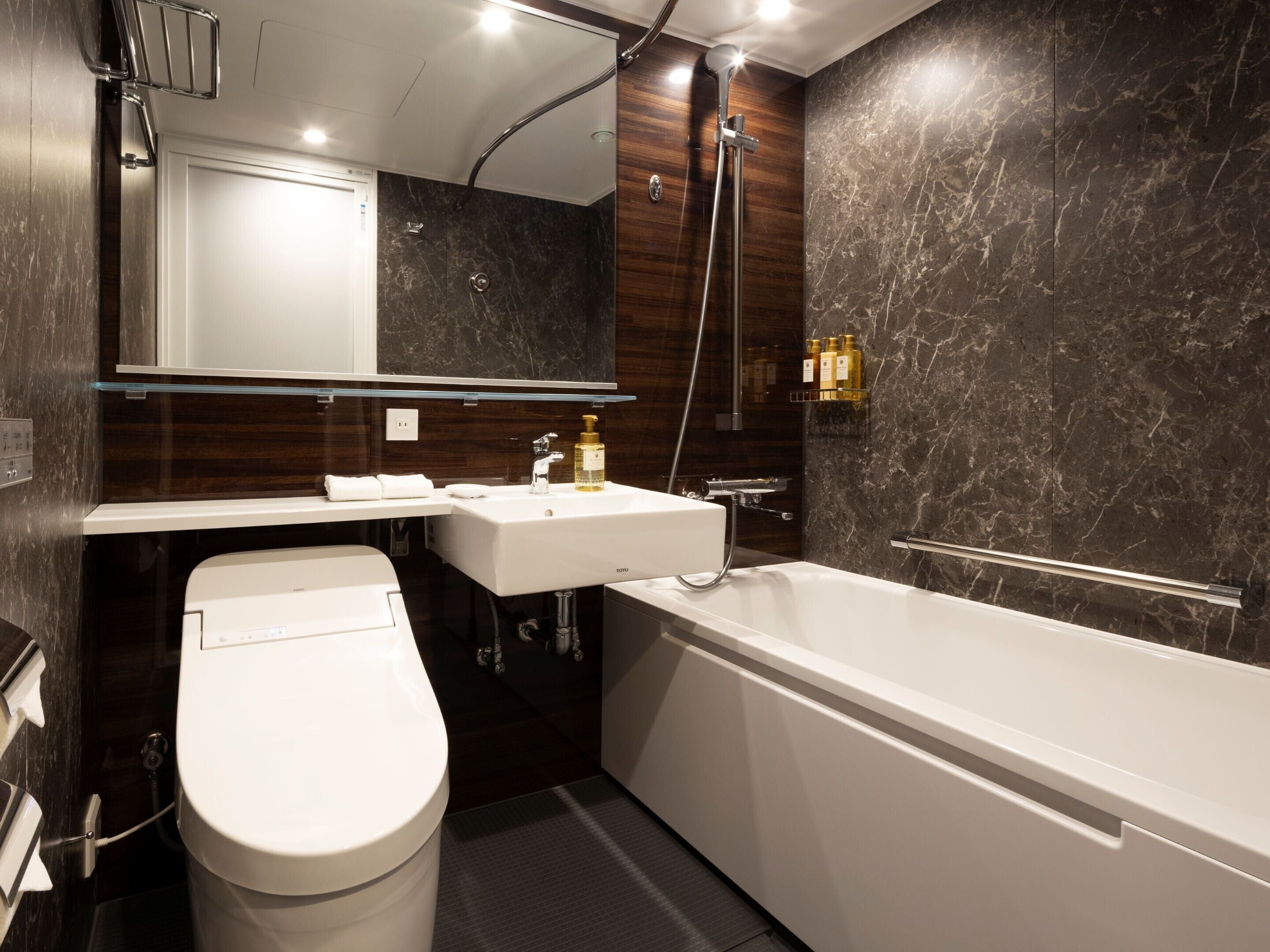 A modern bathroom with a toilet, sink, and bathtub.