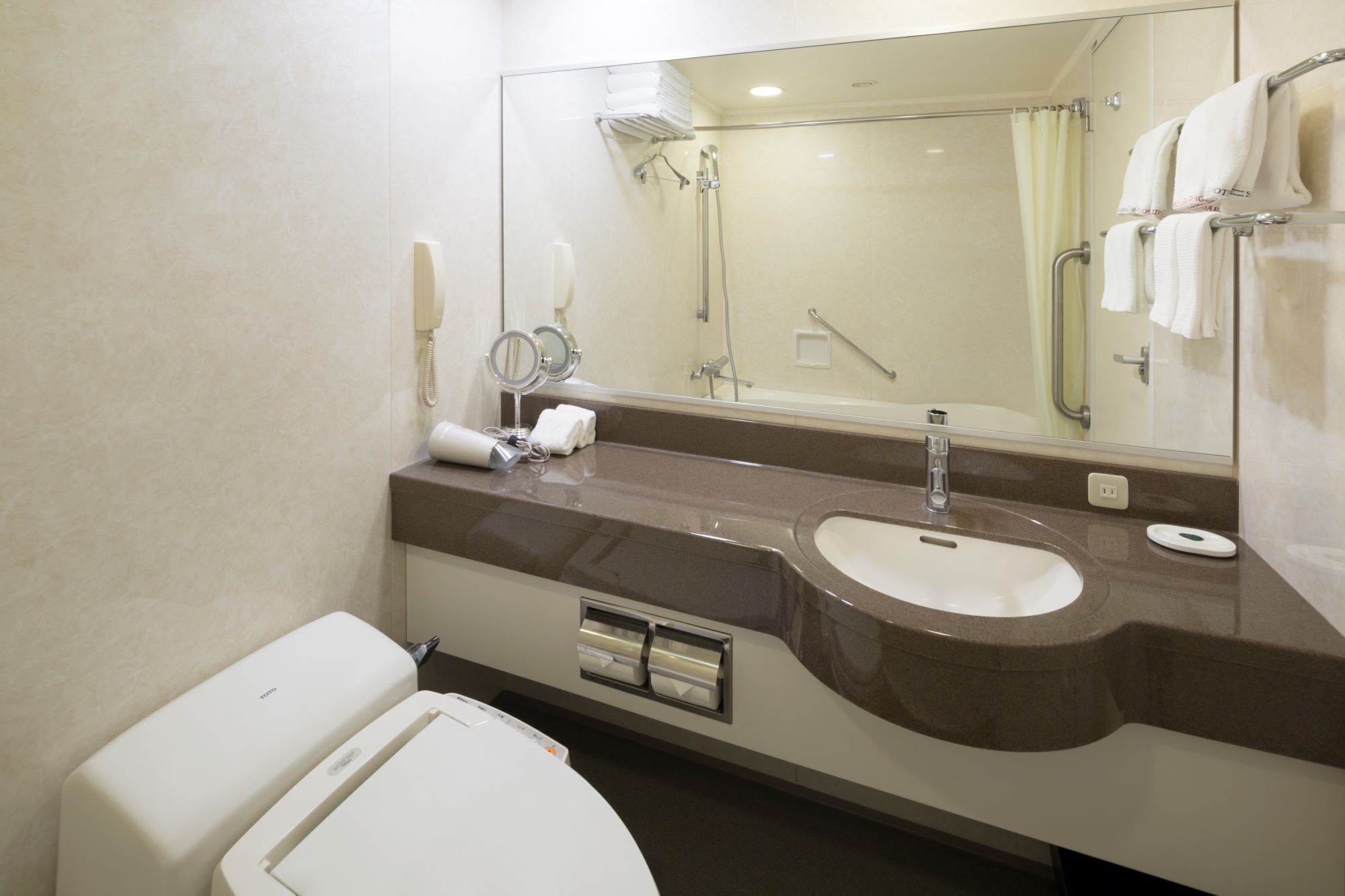 Un baño moderno con un lavamanos grande, espejo y retrete.