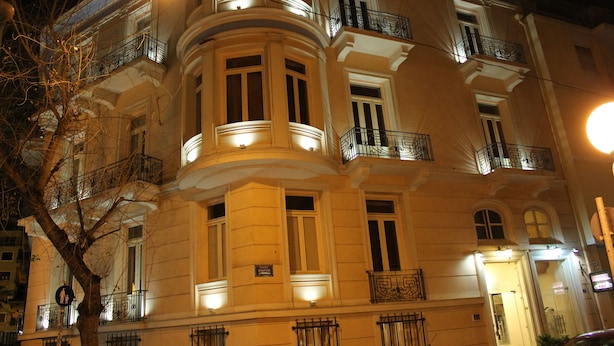 A multi-story building with balconies and illuminated windows at night. - Exis Boutique Hotel (Athens)