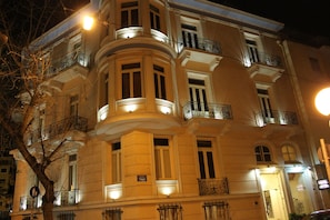 A multi-story building with balconies and illuminated windows at night. - Exis Boutique Hotel (Athens)