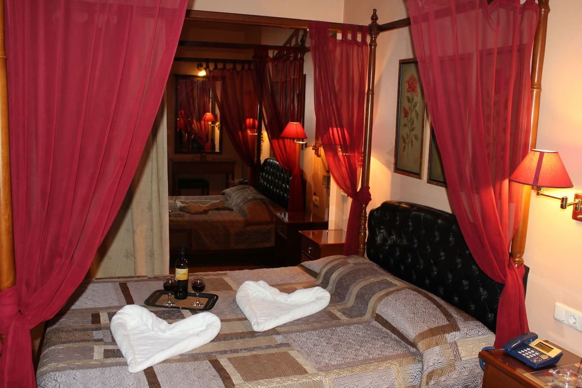 A hotel room with a bed, a bedside table with a lamp, and a telephone.