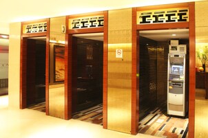 A hotel elevator with a wooden finish and a no smoking sign.