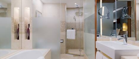 A modern bathroom with a glass-enclosed shower, two sinks, and a large mirror.