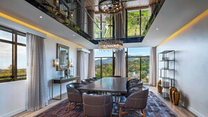A modern dining area with a large table, leather chairs, and a chandelier. - The BRIX, Autograph Collection (Port of Spain)