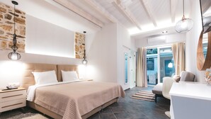 Une chambre moderne avec un grand lit, des tables de chevet, un bureau et une vue sur l’extérieur.