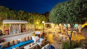 Un espace extérieur aménagé avec un patio couvert, des chaises longues et des tables.
