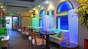Un restaurant au décor moderne, avec une longue table à manger, plusieurs chaises et un canapé.