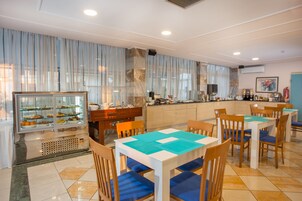 Un restaurante con bufé, mesas y sillas de madera.