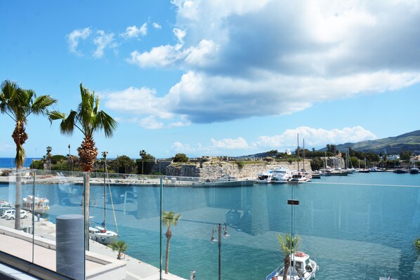 A marina with boats docked, palm trees, and a clear sky. - Kosta Palace (Kos)
