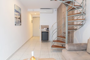 A modern interior with a spiral staircase, a small kitchenette, and a sofa. - Kosta Palace (Kos)